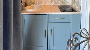 Una cocina con gabinetes grises, una encimera de madera, un fregadero y una estufa.
