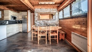Un interior de madera con cocina, mesa de comedor y sillas.
