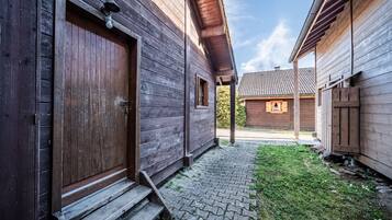 Un bâtiment en bois avec une entrée pavée et un petit espace verdoyant.