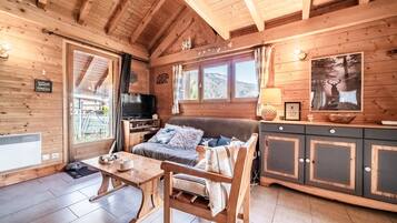 Un intérieur en bois avec un canapé, une table et des armoires.