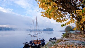 A calm lake with boats, a dock, and autumn leaves on the shore. - Le Balcon De Loire - Curry Room: Escape and Serenity by the Loire (La Chapelle sur Loire)