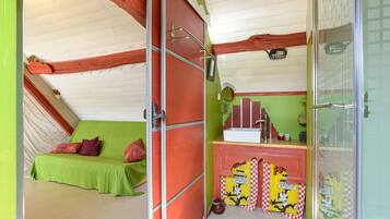 Una habitación con cama, un baño pequeño con lavamanos y un espejo.