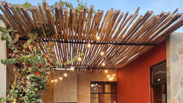 Eine moderne Terrassengrundstück mit Holz-Pergola, Sitzgelegenheit und einem Pool.