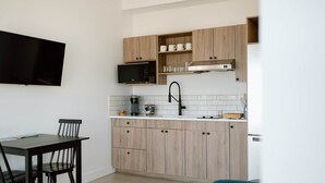 Una cocina moderna con armarios de madera, microondas y cafetera.