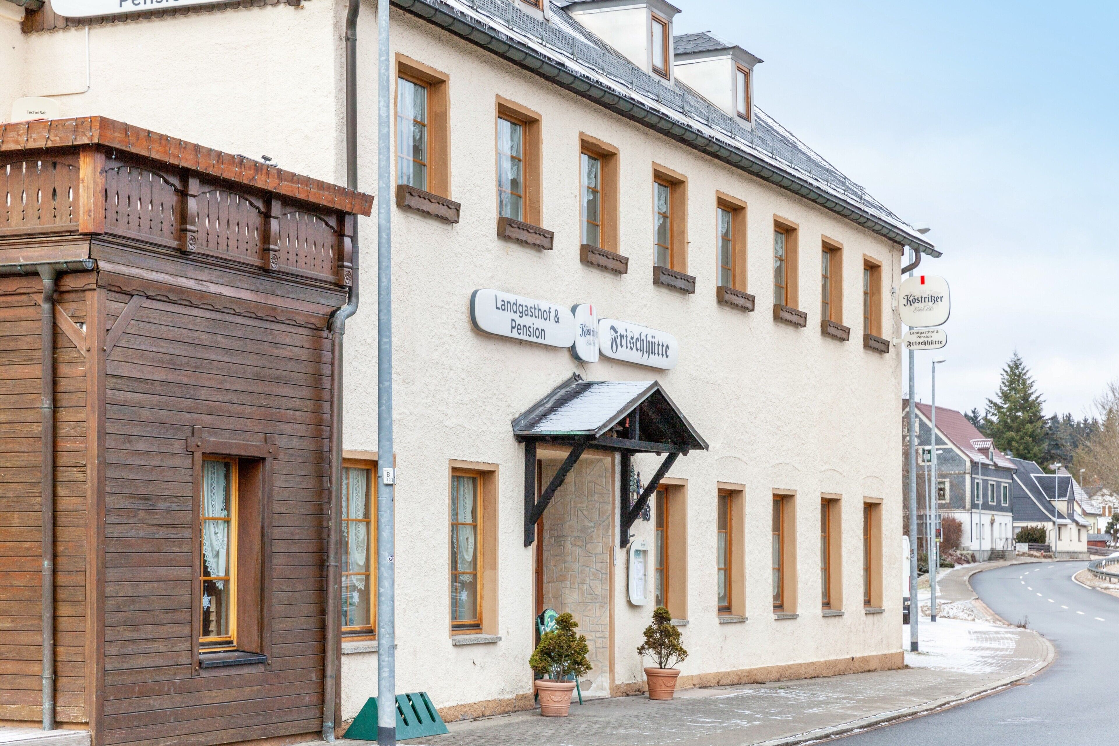 Ein Gebäude mit einem Schild, auf dem 'Landgasthof & Pension' und 'Frischküche' steht.