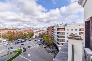 Une vue urbaine avec un carrefour animé, des immeubles et un ciel dégagé.