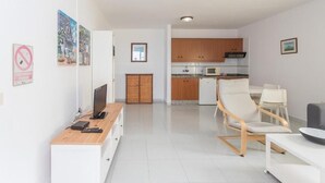 Een modern appartement met keuken, eethoek en woonkamer.