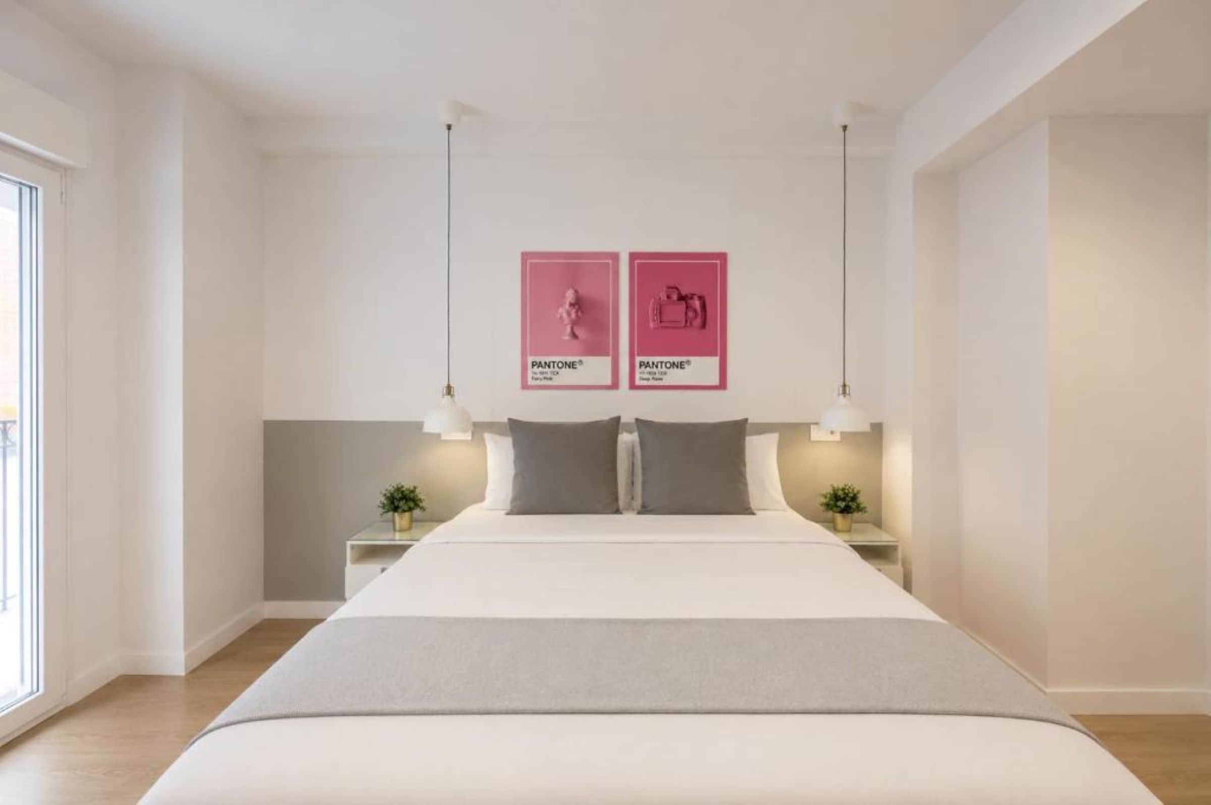 A modern bedroom with a large bed, two bedside tables, and a window.