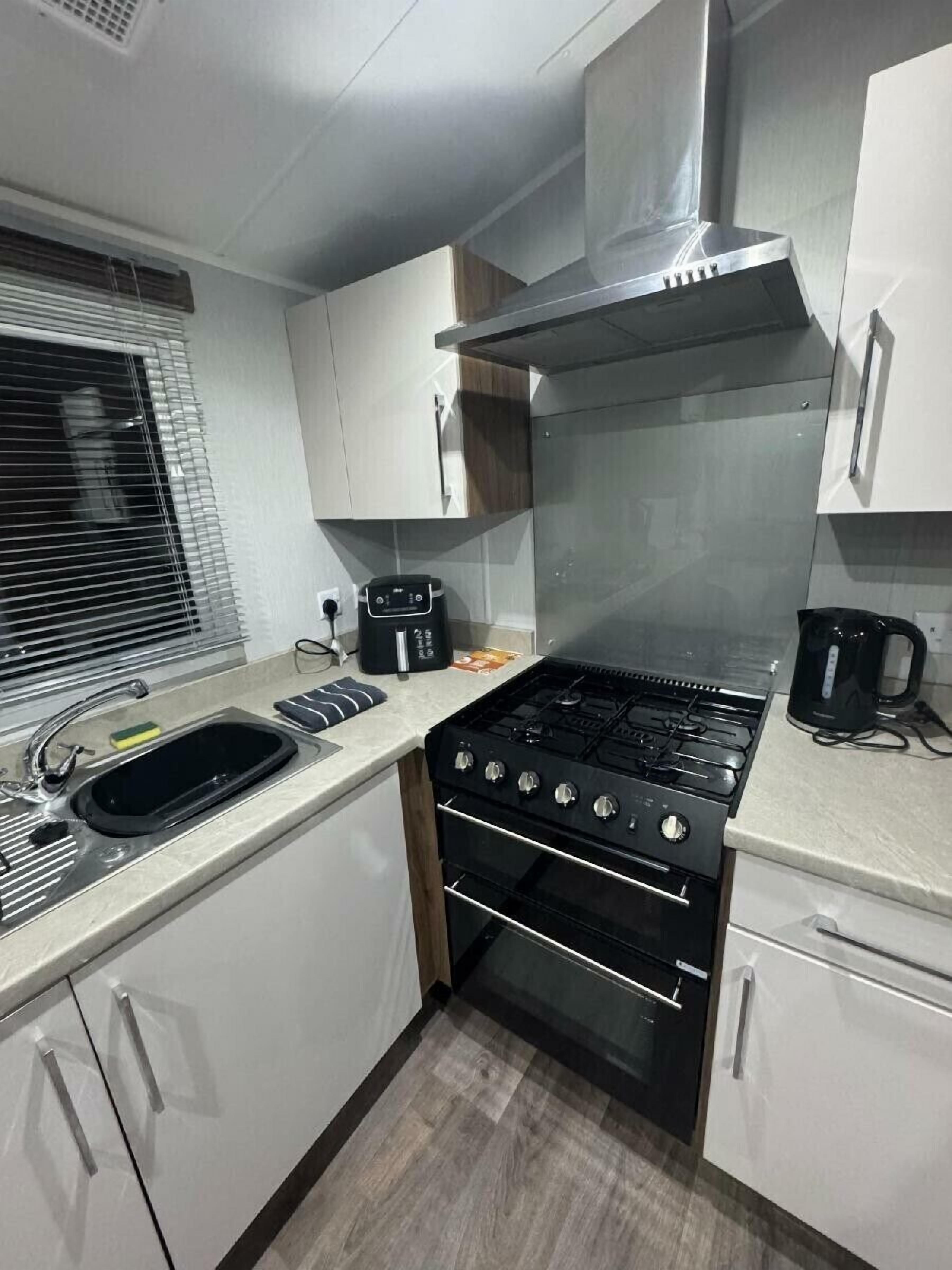 A compact kitchen with a gas stove, oven, and a coffee maker.