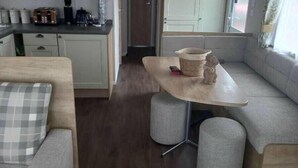 A compact RV interior with a kitchenette, a dining area, and seating. - Skegness Holiday Park 13968 (Skegness)