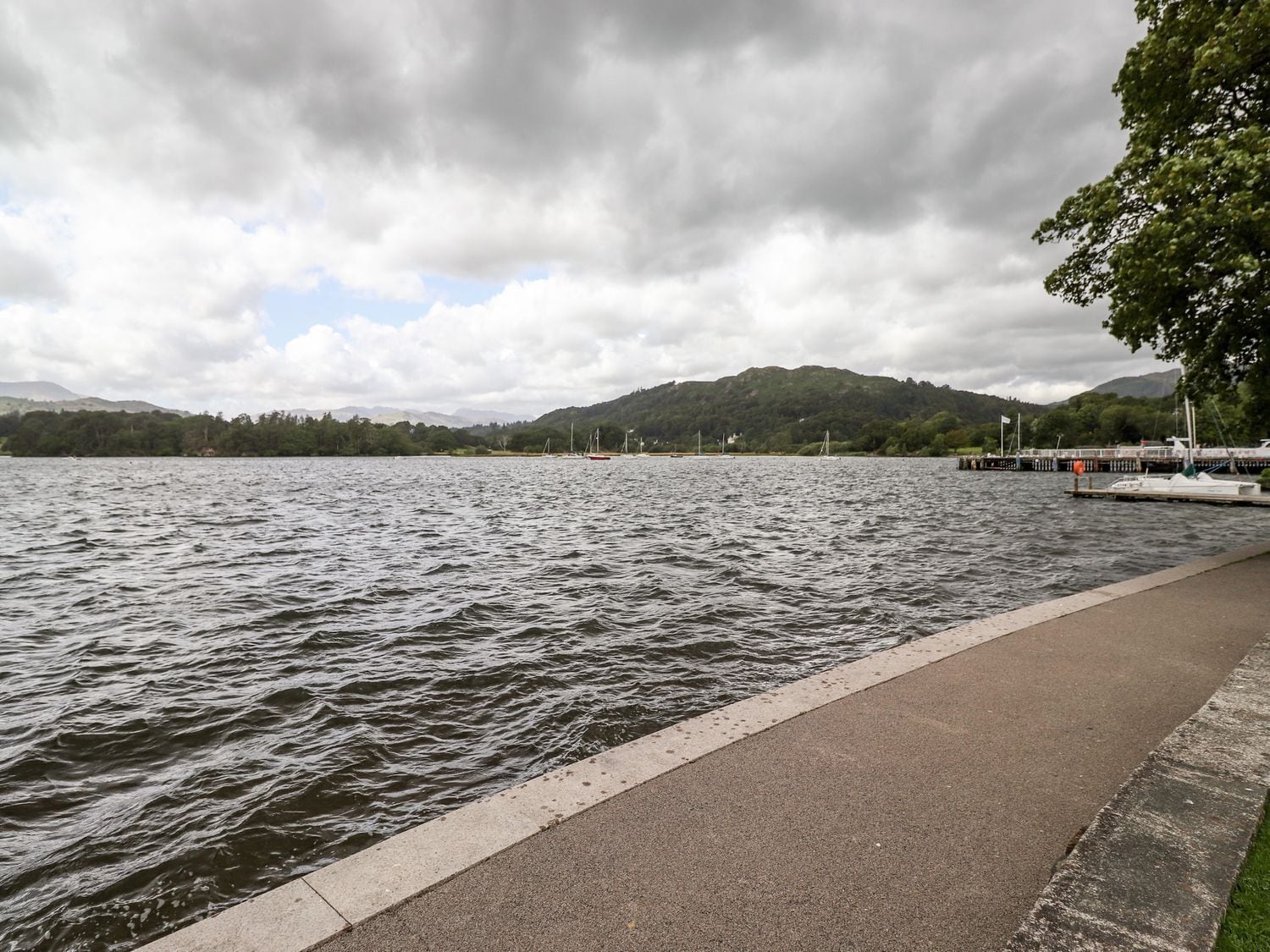 Un lago tranquilo con un muelle y un sendero para caminar a lo largo de la orilla.