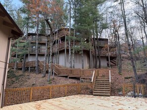 Eine mehrstöckige Holzhütte mit einer Holzdachterrasse und Treppen, die zu den oberen Stockwerken führen.