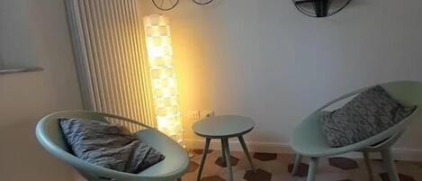 A room with two chairs, a small table, and a wall with decorative items including a bicycle and a sign that says "Life is a Beautiful Ride".