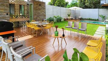 Un espace extérieur aménagé avec une piscine, du mobilier de jardin et un barbecue.