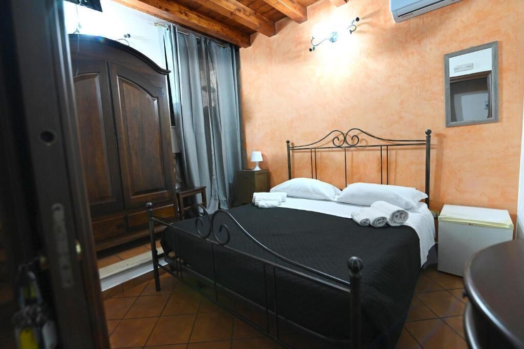 Ein Schlafzimmer mit einem Bett, einem Nachttisch, einem Kleiderschrank und einem kleinen Tisch.