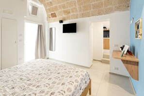 Quarto com cama, televisão e estante de madeira.