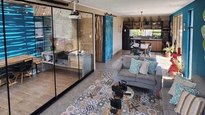 Ein modernes Wohnzimmer mit Sofa, Couchtisch und einem Essbereich mit Tisch und Stühlen.