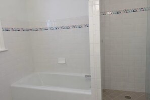 Tina de hidromasaje, toallas, papel de baño 