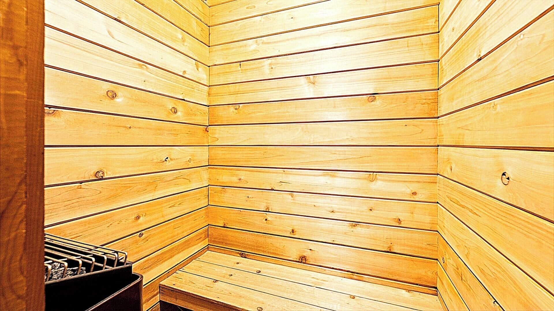 A sauna with wooden walls and a bench.