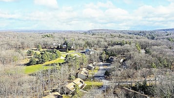 Un quartiere residenziale con case, un campo da golf e un paesaggio collinare.