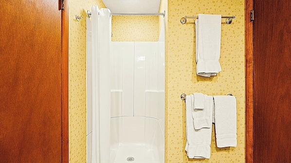 A bathroom with a white bathtub, a white toilet, and a towel rack with two towels. - Westwood Condos by Coolvacay (Lake Harmony)