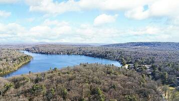 Un lac entouré de collines boisées, sous un ciel dégagé.