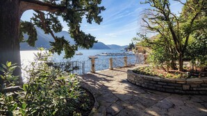 A stone pathway leading to a waterfront with a view of the sea and mountains. - Villa Fisogni - App. 1 "Norma" (Moltrasio)