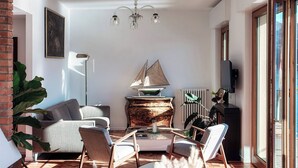 A modern living room with a sailboat model, a chandelier, and a large plant. - Villa Fisogni - App. 1 "Norma" (Moltrasio)