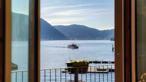 A view of a boat on a calm lake with mountains in the background. - Villa Fisogni - App. 1 "Norma" (Moltrasio)