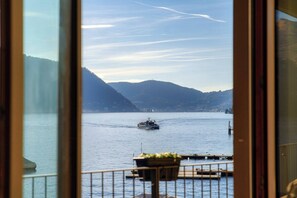 Ein Boot auf einem ruhigen See, im Hintergrund Berge.