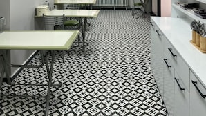 A kitchen with a tiled floor, white cabinets, and a window with a view of a building outside. - Şahin Otel (Biga)