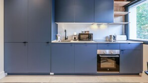 Una cocina moderna con armarios azul oscuro, un microondas, un tostador y un horno.