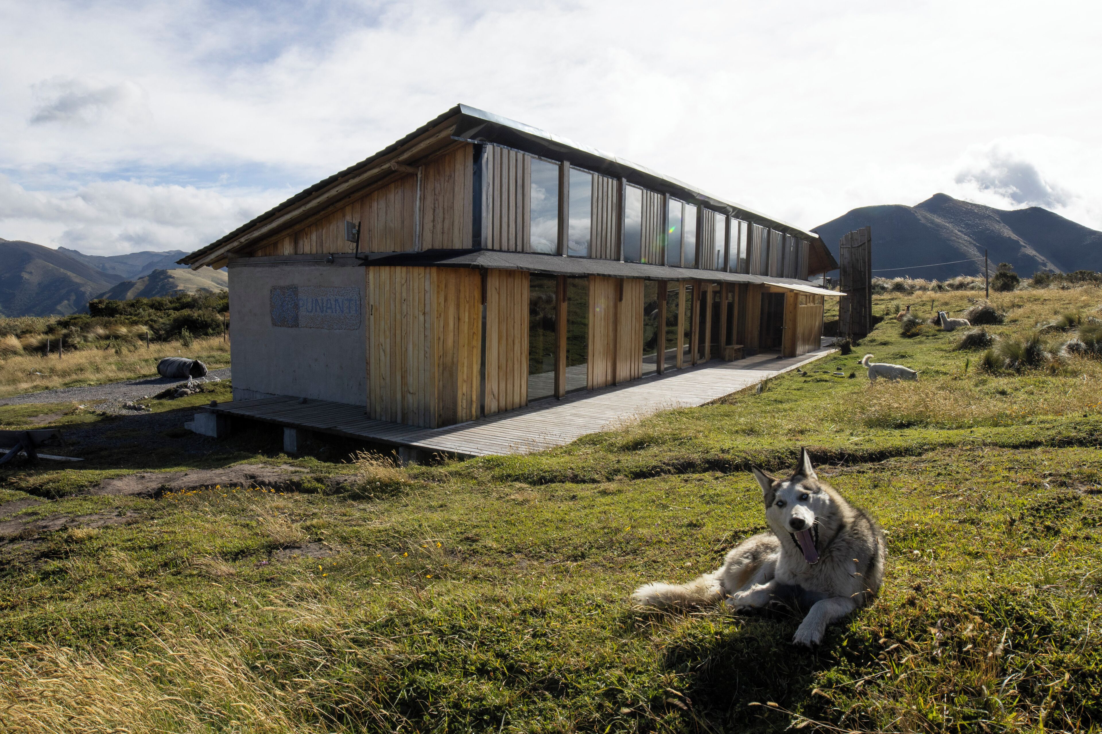 Une cabane moderne en bois, dotée d’une terrasse en bois et d’une grande baie vitrée.