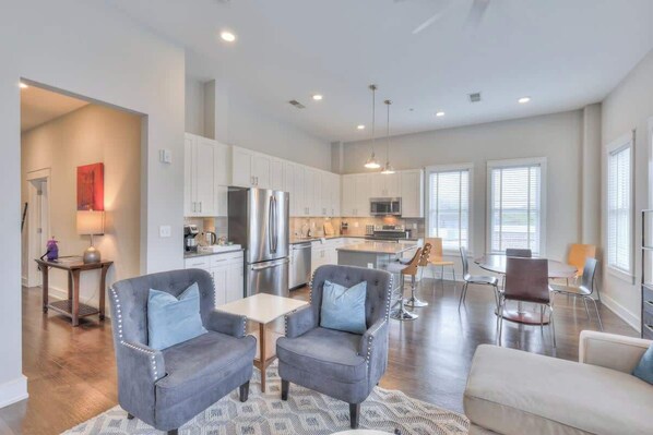 A spacious living area with a kitchen, dining area, and seating. - 2-BR condo in 12 South I Unit 201 (Nashville)