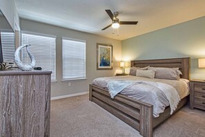 Ein Schlafzimmer mit einem hölzernen Bett, einem Deckenventilator und zwei Nachttischlampen.