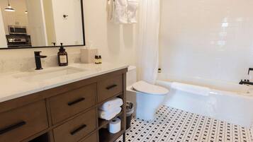A modern bathroom with a white sink, vanity, and a bathtub.