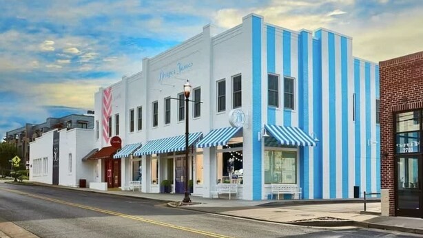 A white building with blue stripes and a sign that reads "Droppers Tins." - 1-BR Condo in 12 South I Unit 202 (Nashville)