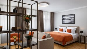 Ein modernes Hotelzimmer mit Bett, einer Couch und einem Bücherregal.