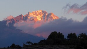 Een bergketen met een opvallende bergtop, deels verborgen door wolken.