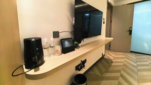 Een hotel receptie met een flatscreen televisie, een digitale kiosk en een prullenbak.