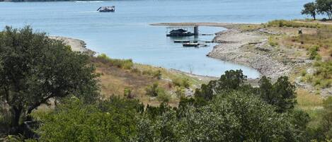 A river with boats, a dock, and a forested area.