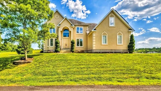 A two-story house with a symmetrical facade, a central entrance, and a well-maintained lawn. - Private Resort! 100" Home Theater, HotTub, Pool, Basketball Court, extra games (Bowie)