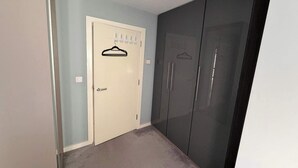 Une pièce avec une porte beige, une armoire sombre et un mur bleu clair.