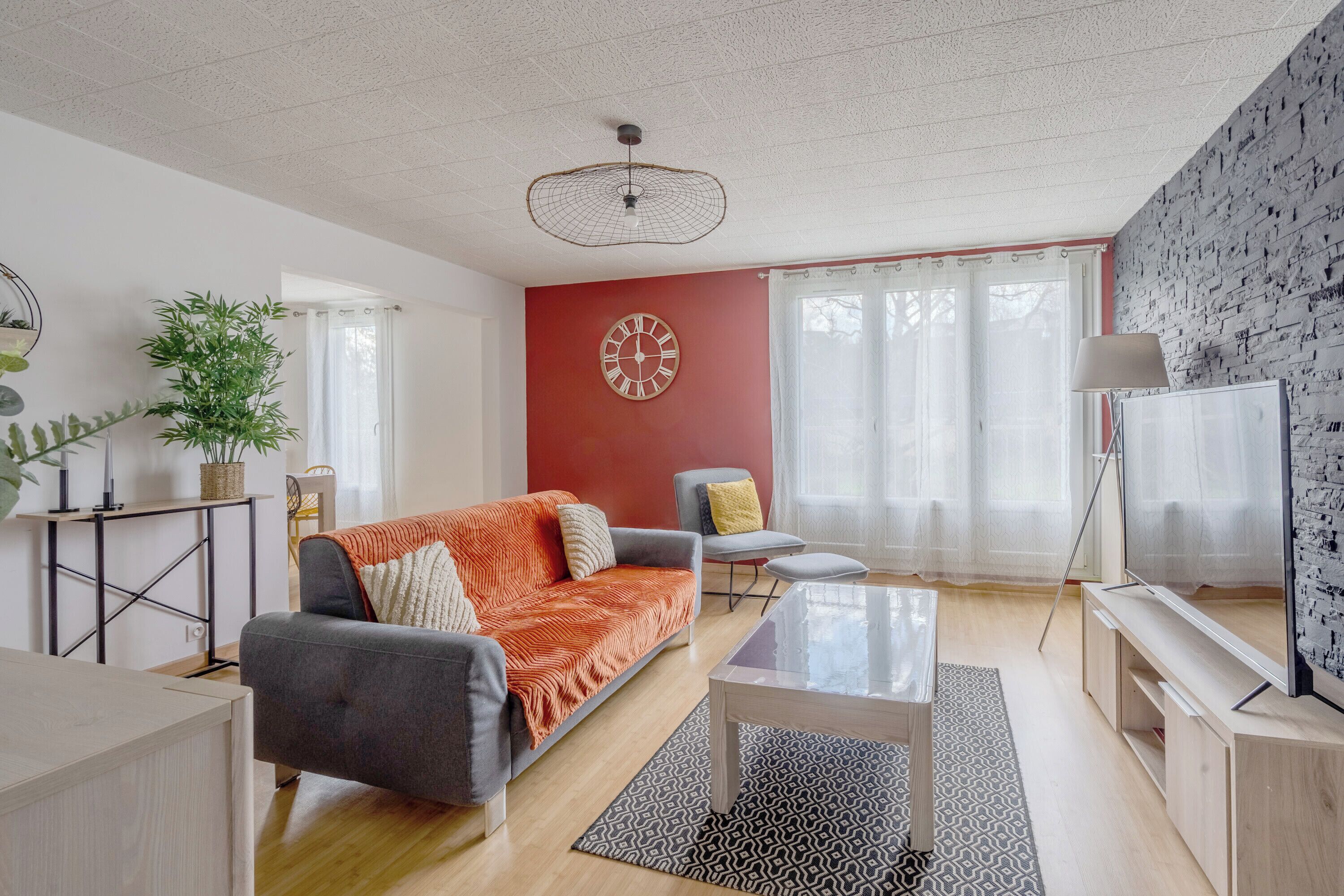 En moderne stue med sofa, sofabord og fjernsyn.