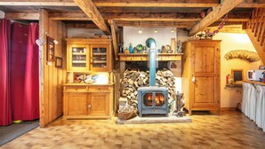 A rustic wooden interior with a wood-burning stove, wooden cabinets, and a tiled floor. - Le Villard - Montagne - Wifi (VILLARD REYMOND)