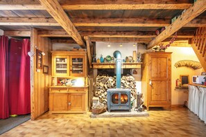 A rustic wooden interior with a wood-burning stove, wooden cabinets, and a tiled floor. - Le Villard - Montagne - Wifi (VILLARD REYMOND)