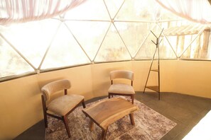 A room with a geometric glass ceiling, two upholstered chairs, a wooden coffee table, and a tripod stand. - LUMBAI GLAMPING MAZAMITLA (Mazamitla)