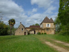 Ein Steinhaus mit einem Dreiecksgiebel und einem kleinen Anbau.