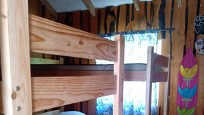 Dormitorio con literas, paredes de madera y una ventana.
