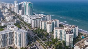 Paisagem costeira com edifícios altos, uma praia e céu claro.